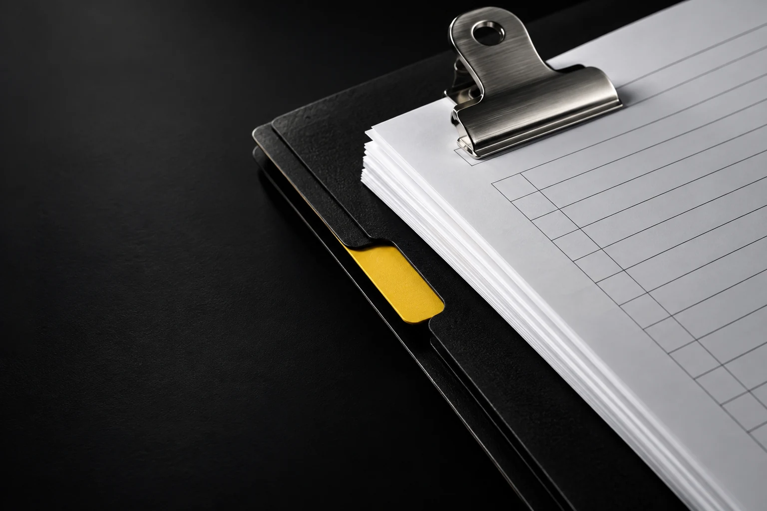 Illustrative close-up of a black insurance folder, paper records and a yellow index tab